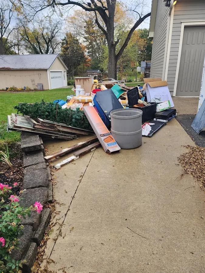 Dumpster being loaded with debris for 12 Yard Dumpster Rental in Colona